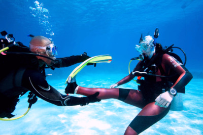 PADI_Rescue_diver_course_Bali_cramp_removal_exercice_with_2_students