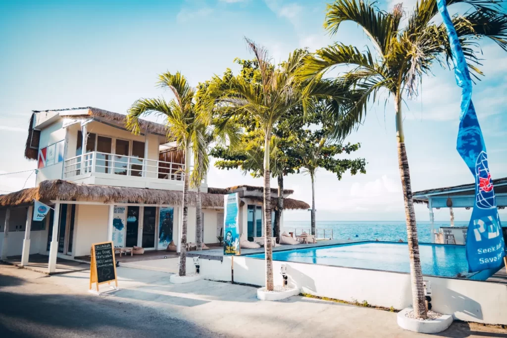 Photo of a dive center in bali, can see the pool, sea, PADI flag and Diving flag, coconut tree