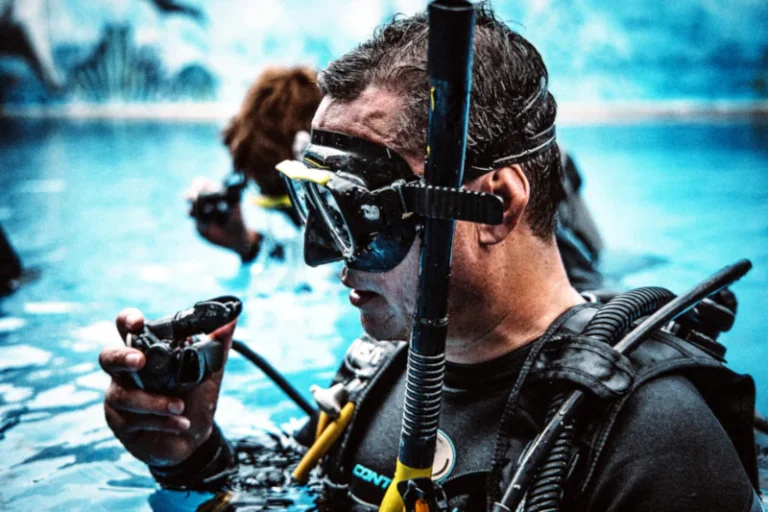 PADI student diver standing in a pool in full scuba gear checking his regulator before his first open water dive in Bali
